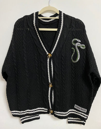 Black cardigan with green and silver snake patch on the chest.